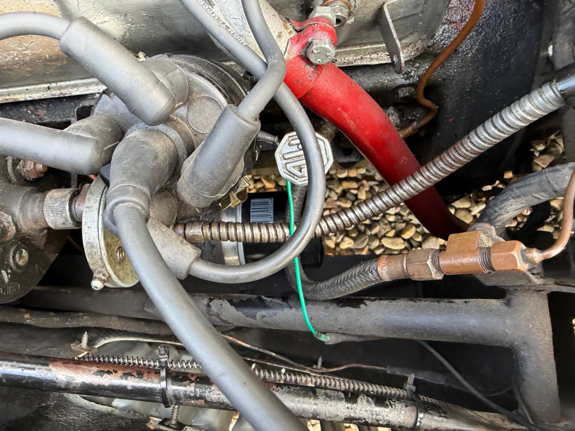 A reproduction distributor in situ with modern push-on HT leads rather than the correct period screw-in acorn terminals. The mismatch is a common tell-tale of an uncalibrated replacement unit and lead set fitted together.