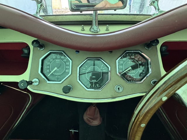 Direct view of the MG TF 1500 dashboard with three octagonal Smiths instrument pods: tachometer, central combined gauge and speedometer