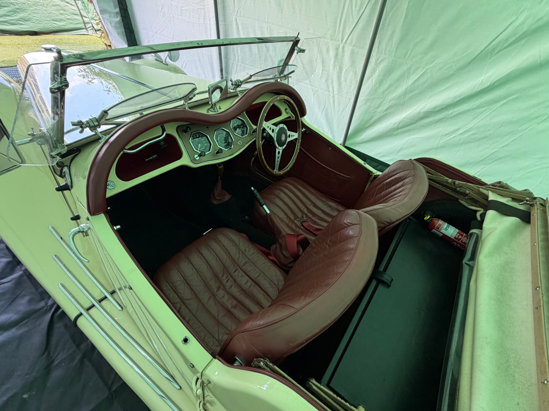 Wide interior view of a cream MG TF 1500 from the passenger side, showing maroon leather seats, the dashboard and the gear lever