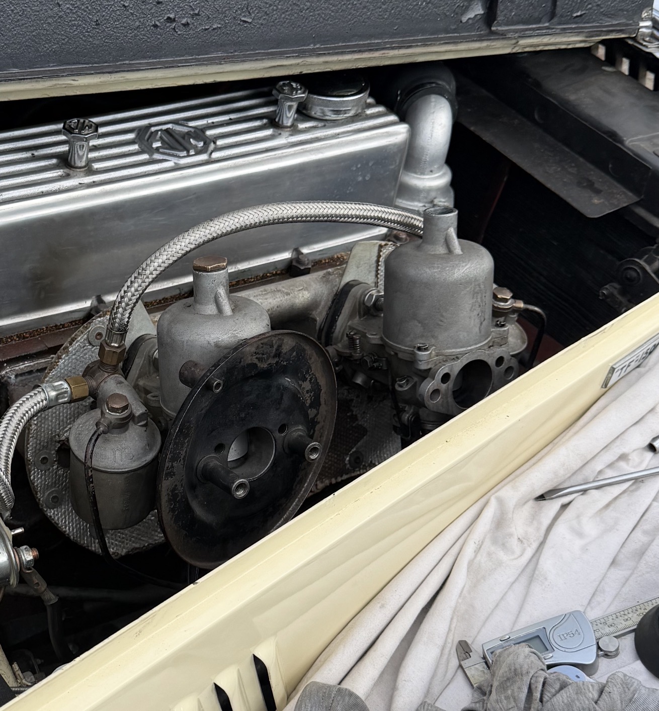 The carburettor pair on the author's TF 1500 with the rear air filter off, exposing the intake mouth and float chamber.