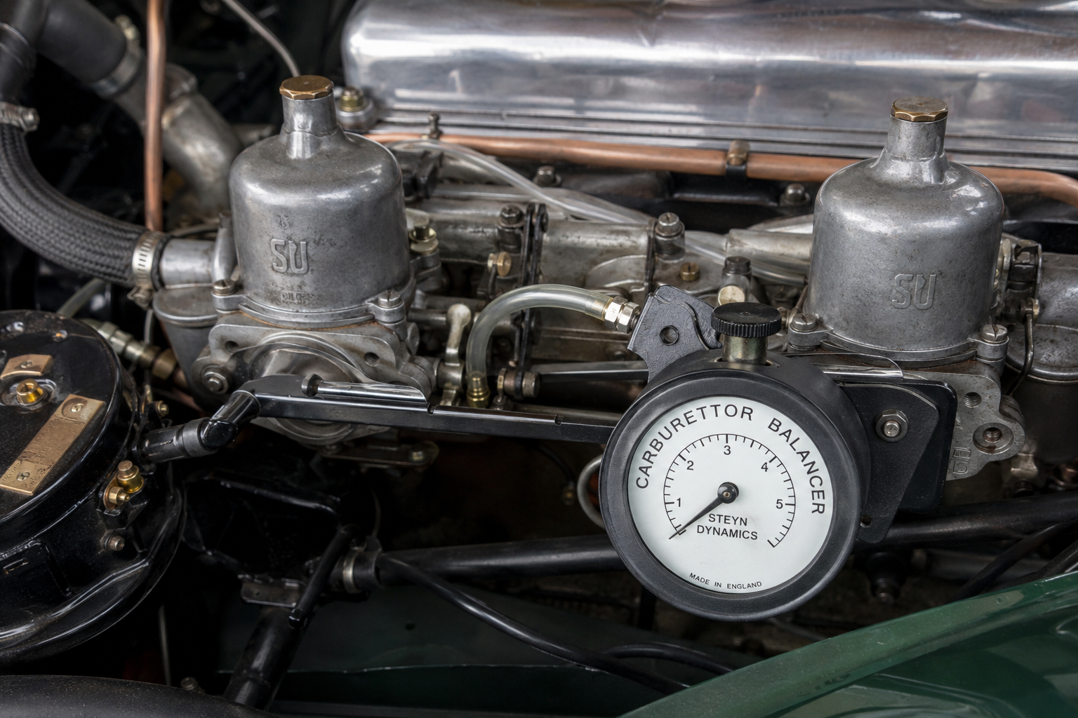 A carburettor balance meter fitted to one of the intakes, mid-adjustment.